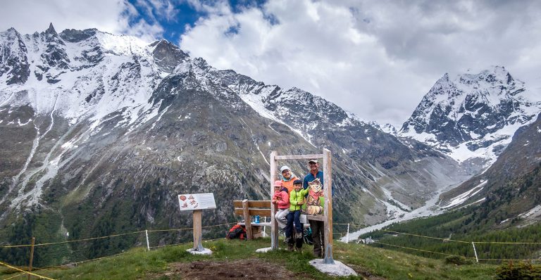 family standing at a photo post on the marmot hike in Arolla