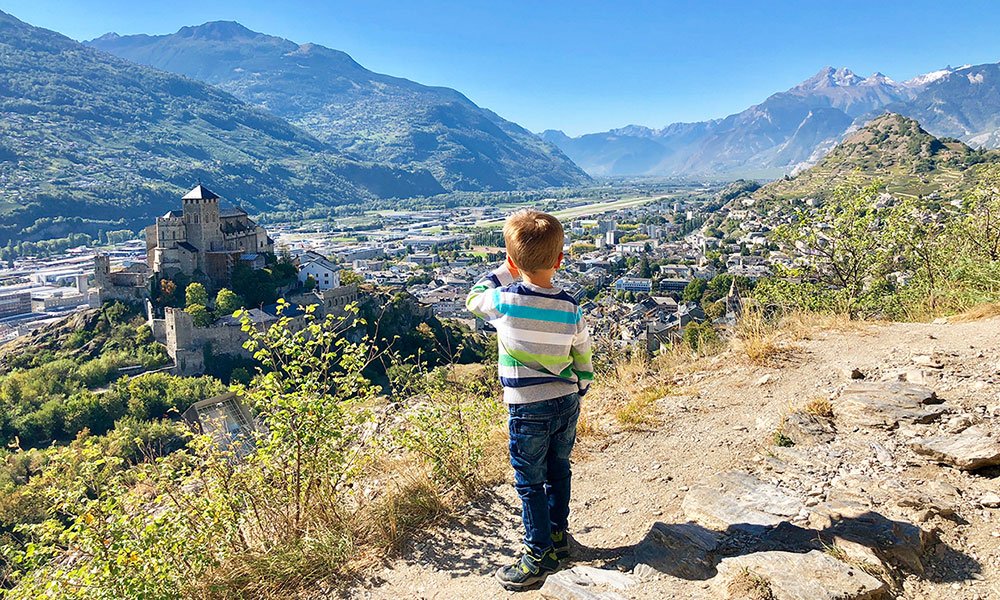 Boy looking at Sion Castel on our road trip through Switzerland 