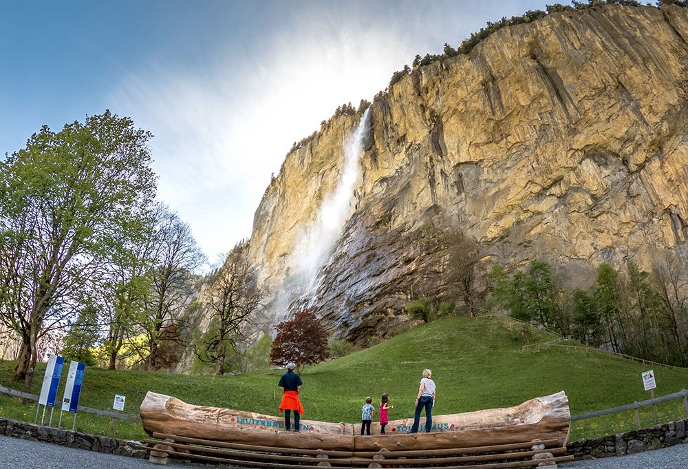 family standing and looking at the Staubbach fall in Lauterbrunnen