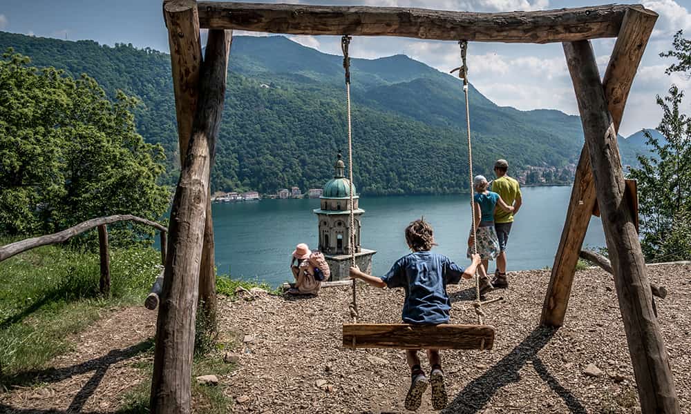 Family by a swing overlooking Morcote and Lake Lugano in Ticino Switzerland