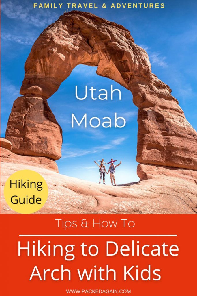 family standing under the Delicate Arches whilst hiking delicate Arch trail