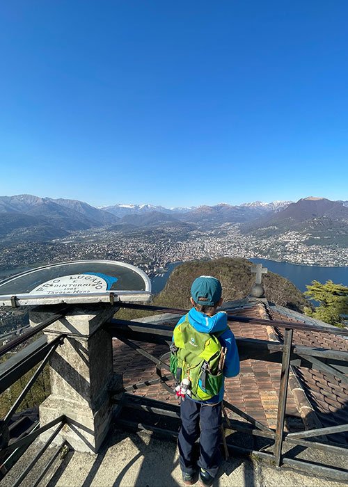 a boy marvelling at the view of lugano from San Salvatore