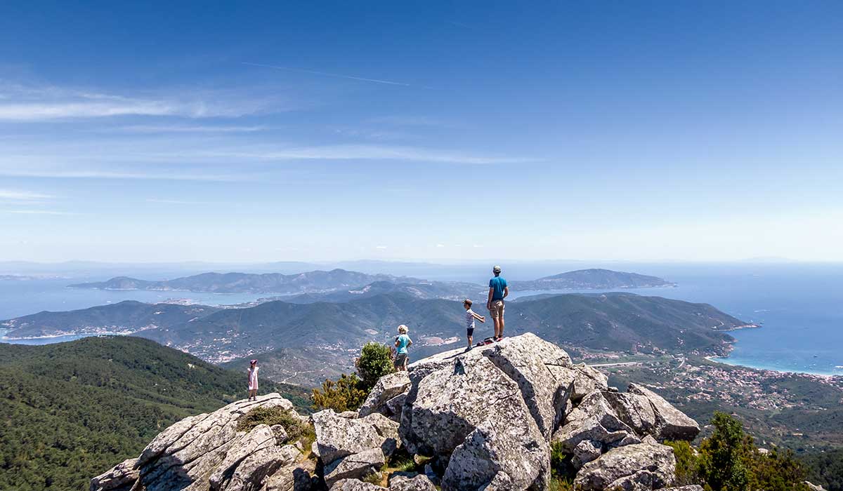family standing at the top of the mountain in elba