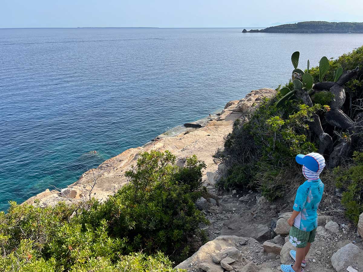 boy standing at the top of a beach in Elba le piscine