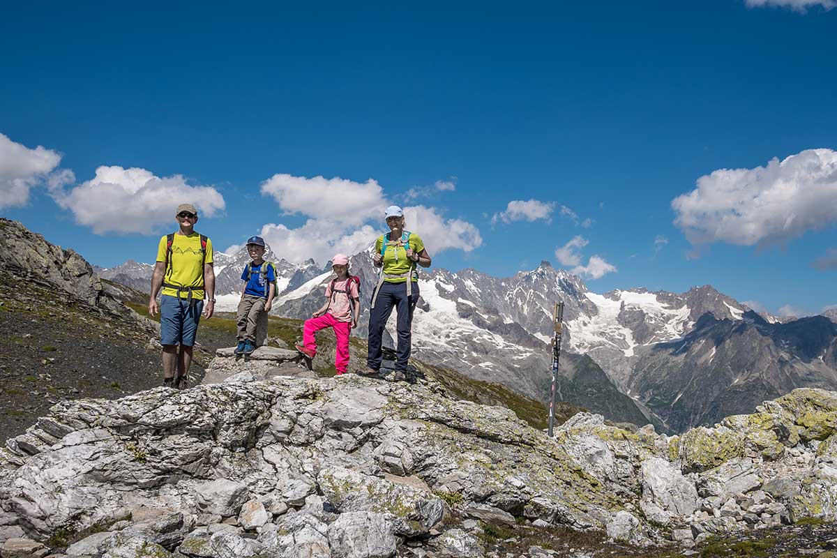 family standing at the ridge to the fenetre de ferret switzerland 