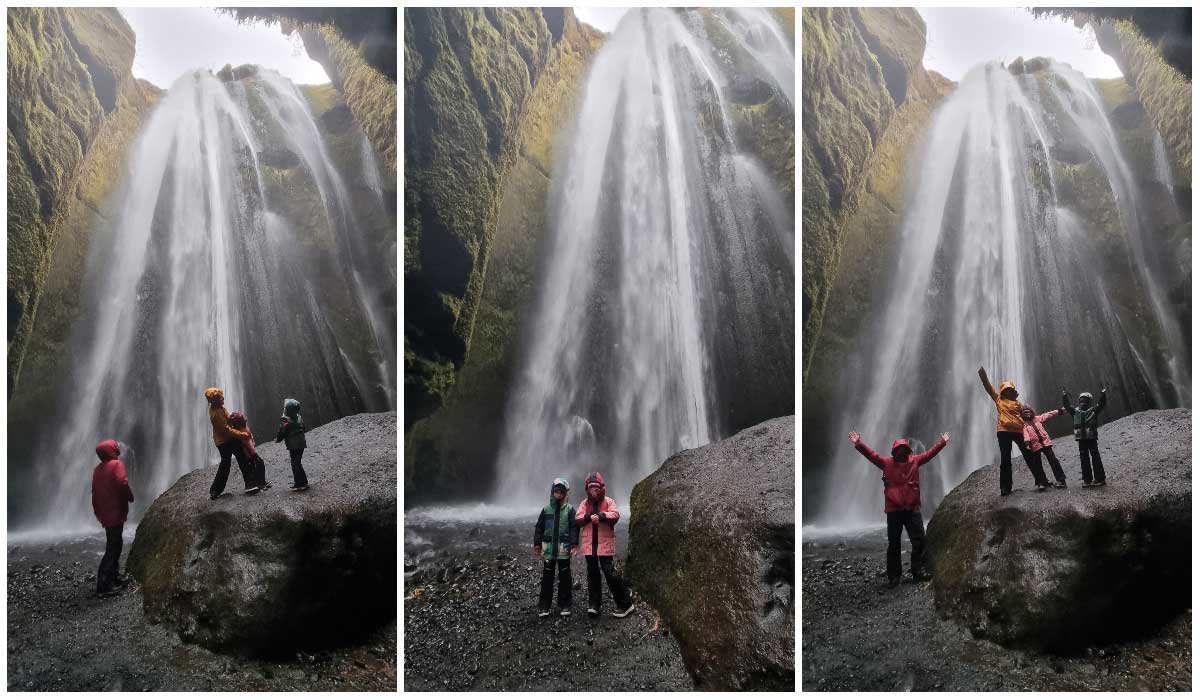 Familie in der Nähe eines großen Wasserfalls in Island - dem Gljúfrabúi-Wasserfall.