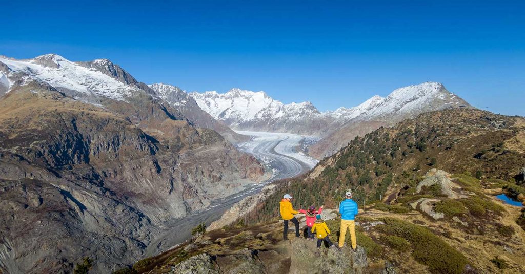 Family standing at the Hohfluh Aletsch Glacier Viewpoint in Switzerland