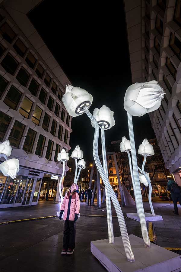 a girl standing within the light tulips at the LILU light festival in Lucerne