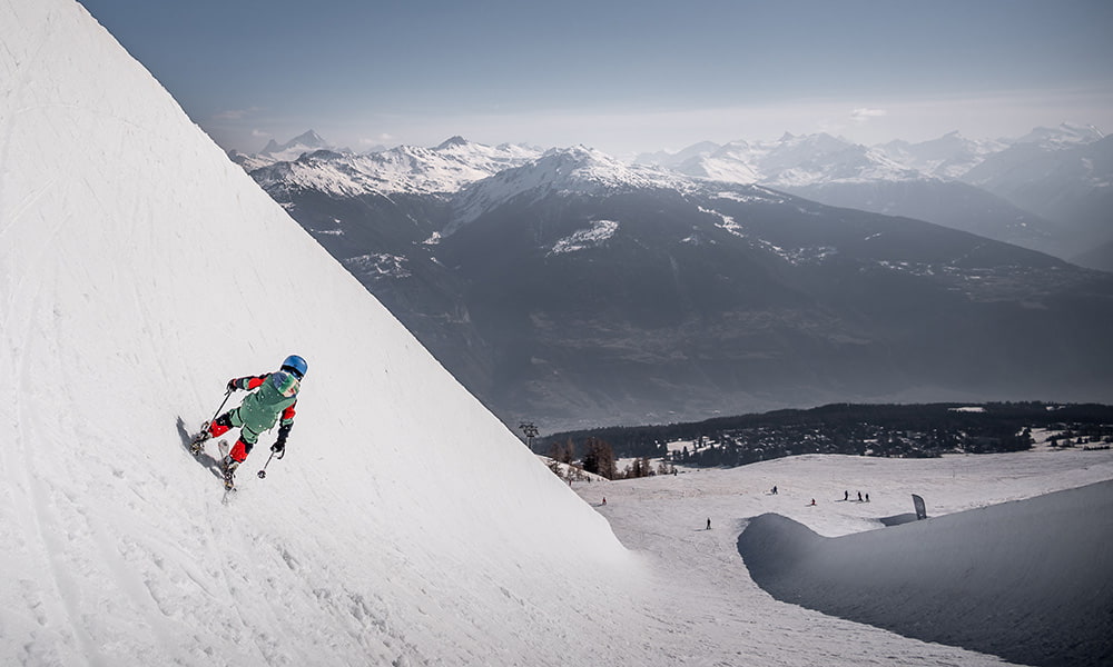 a boy skiing the olympic halfpipe of the Alaia park