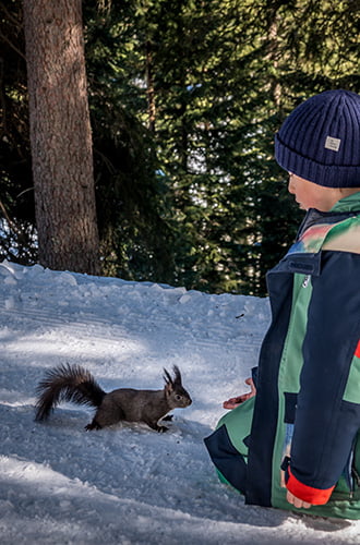 a boy with a squirrel close by