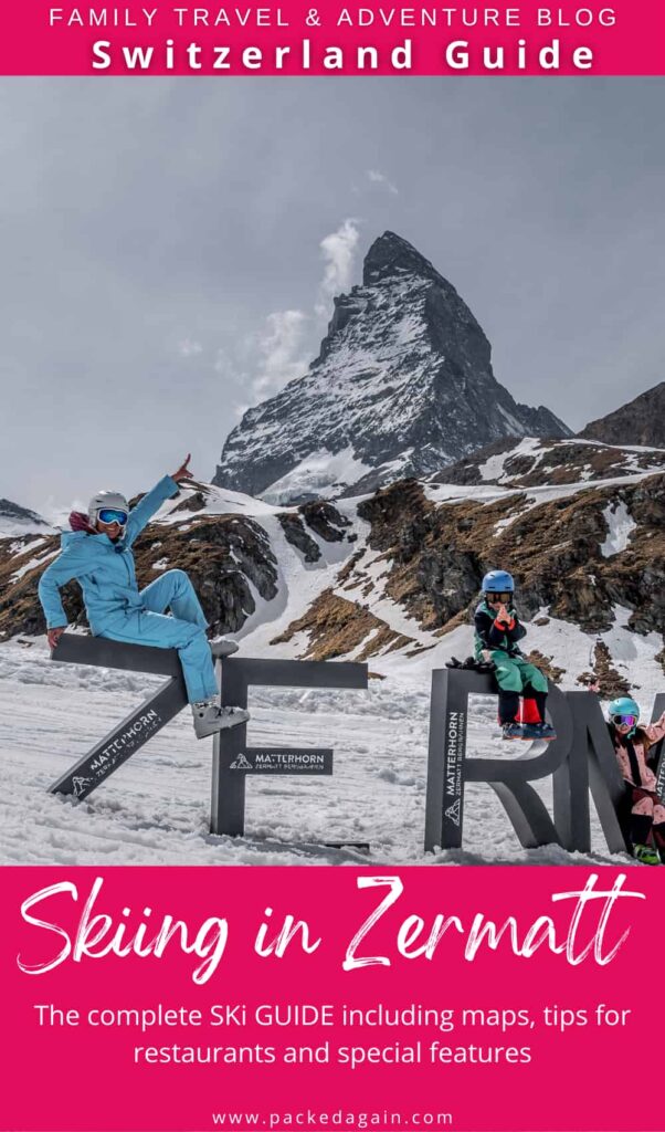 a family sitting on large Zermatt letters in winter