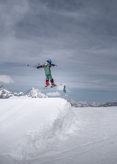 a boy jumping over a kicker in the Zermatt snow park whilst skiing in zermatt