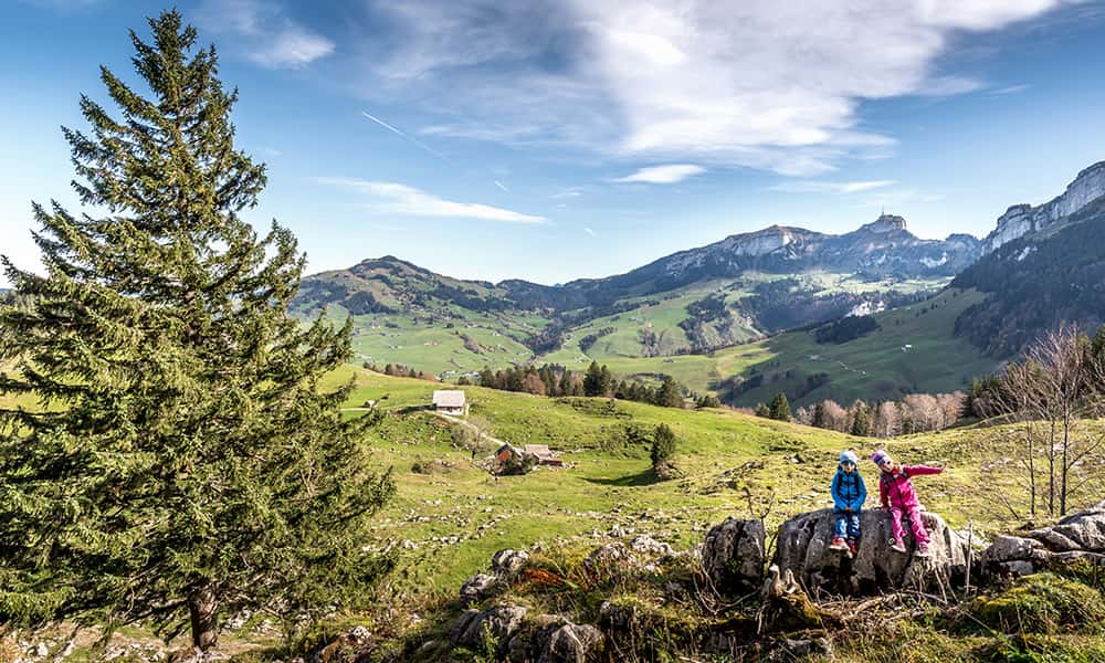 Children sitting on a rock amongst the Alpstein region