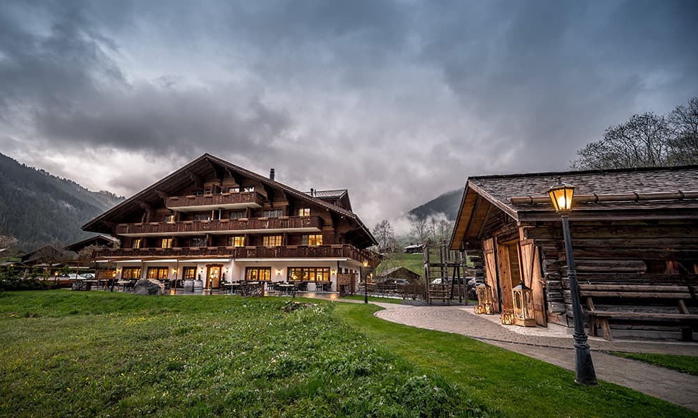 a swiss Hotel Alpenland Lauenen during the evening with lights on