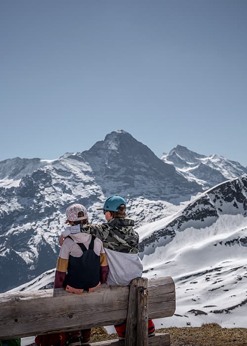 children sitting on a bench whilst hiking to Bachalpsee in Grindelwald