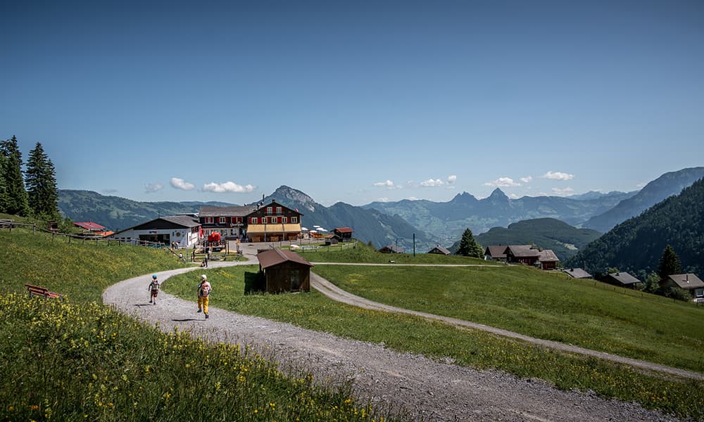 kids running towards a mountain hut in Klewenalp