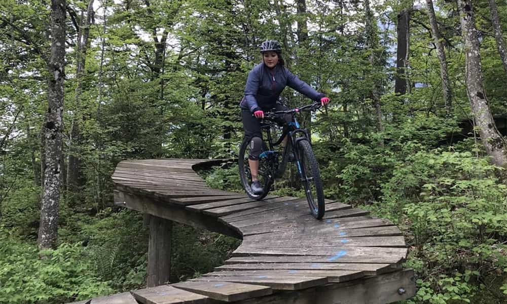 a woman on a wooden high bike trail in emmetten