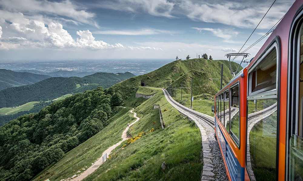 red train riding up mount Generoso in Ticino