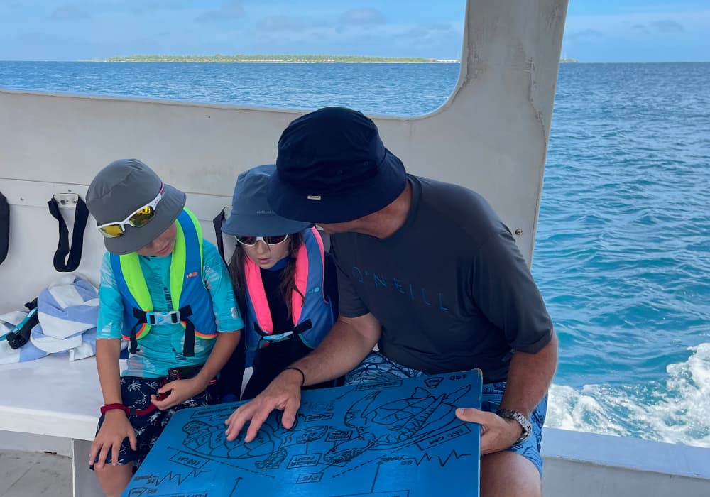 children with a dad on a maldivian snorkelling boar 