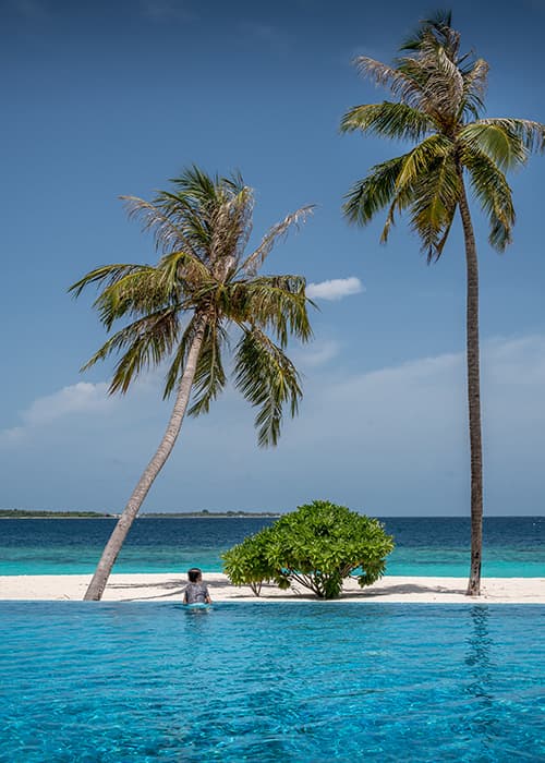 a boy looking out of the swimming pool on an Maldivian island