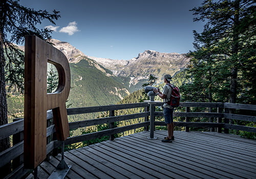a man standing on the platform at the bisse du ro in Crans Montana