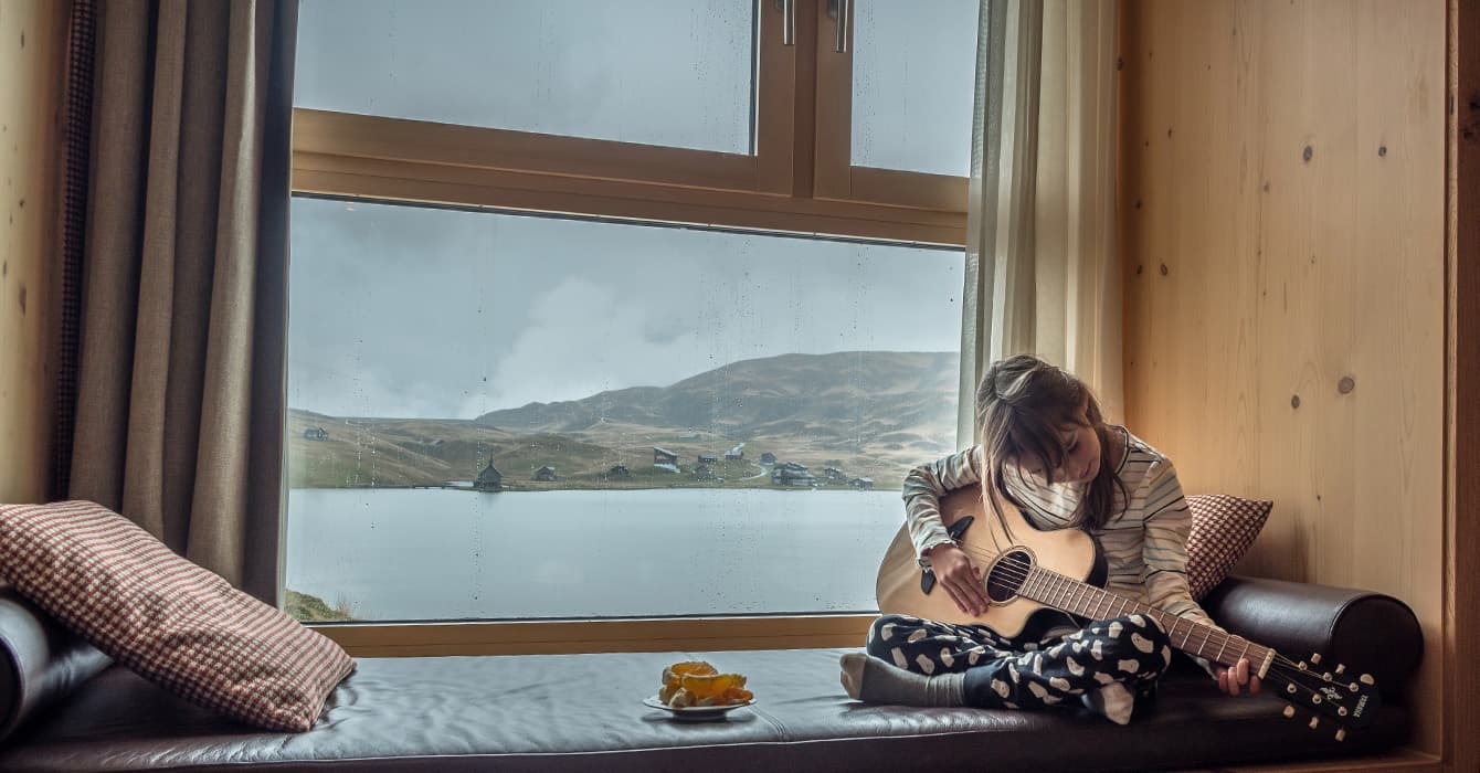 a girl playing her guitar in a swiss hotel