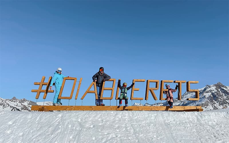 family standing on wooden letters reading diablerets