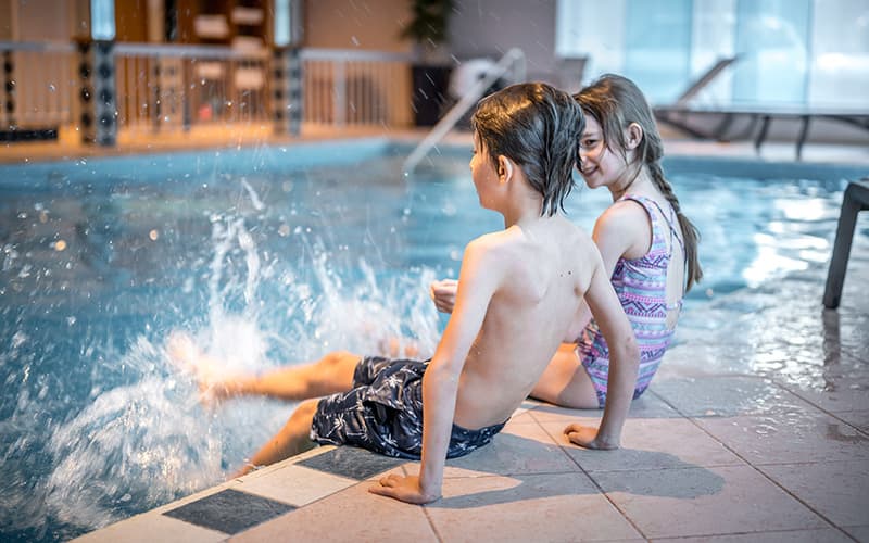 children splashing in the pool area of a hotel