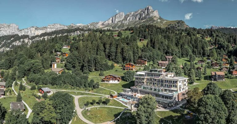 panoramic shot of he Swiss hotel Märchenhotel in Braunwald with mountains in the back