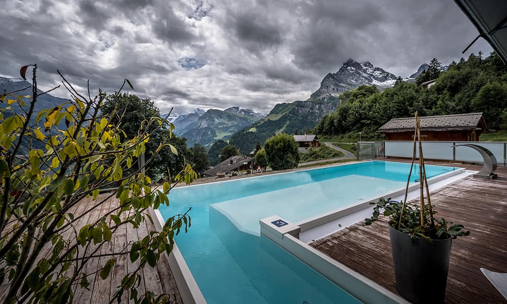 the infinity pool at hotel Märchenhotel looking over to some Glarnerland mountains during a cloudy day