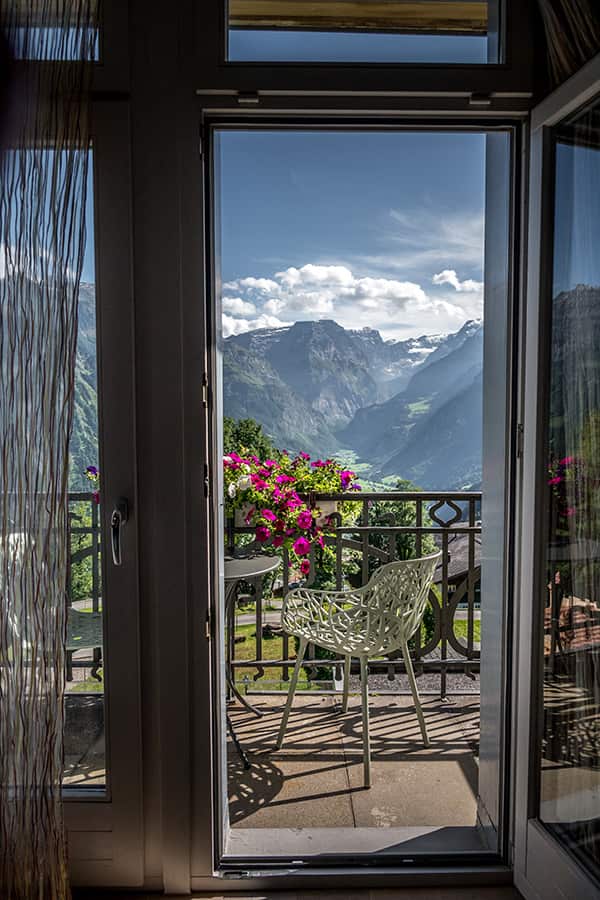 view over a balcony towards the mountain with flowers in front