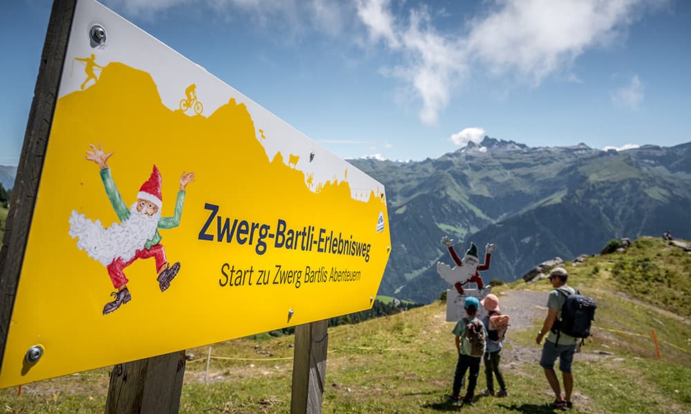 hiking signe with the writing Zwerg Bartli Erlebsnisweg in the mountains