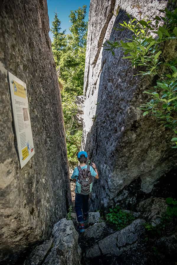 a boy hiking in Braunwald between two large rocks