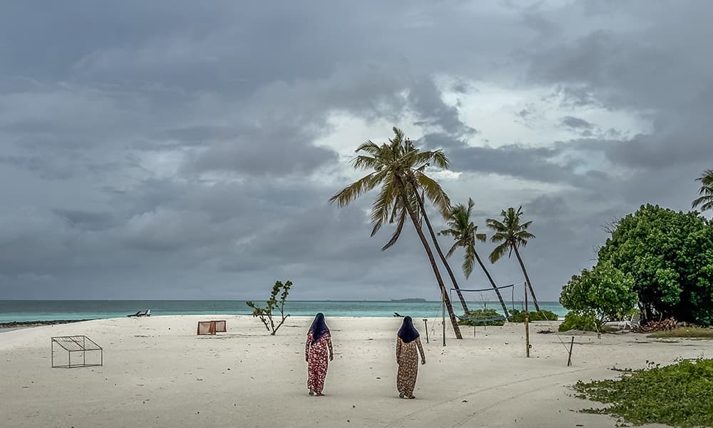 Maldivian muslim woman walking at a beach