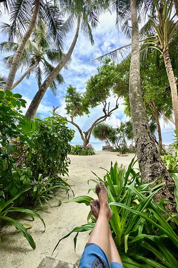 a sea view from a room showing only the feet of the person admiring the view
