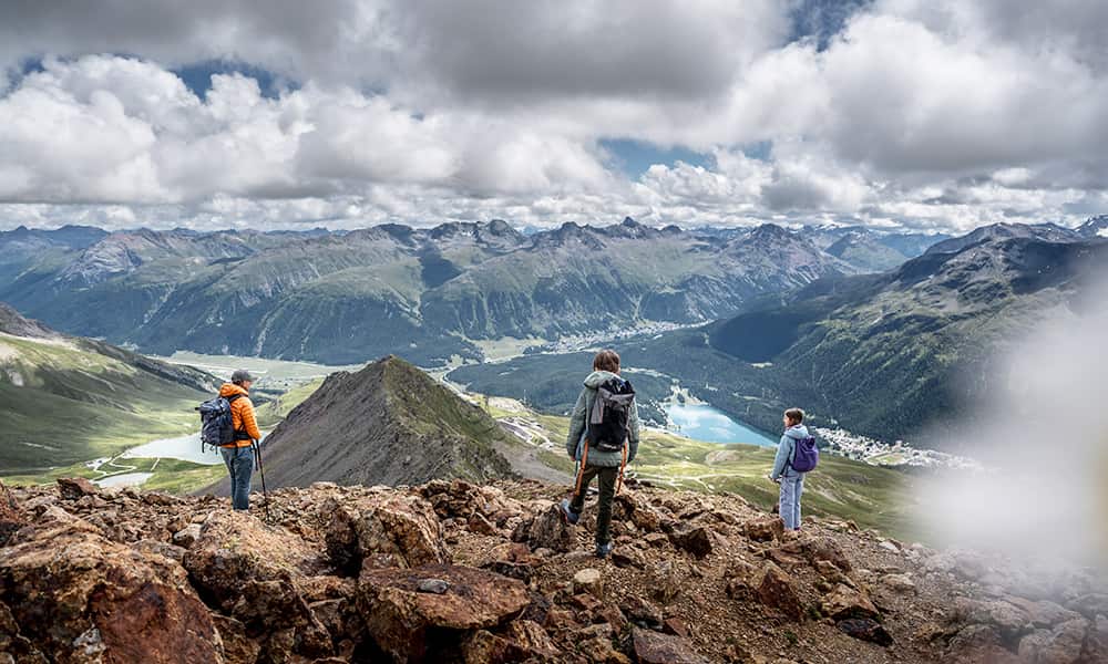 a family standing atop Piz Nair on a slightly cloudy day in Engadin
