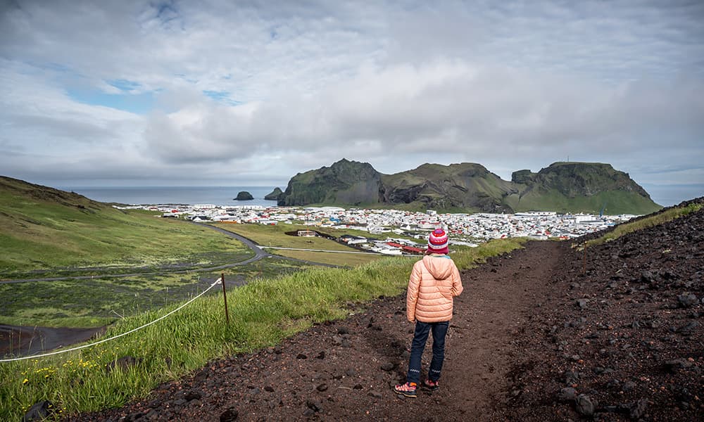 a gril in a pink jacket hiking up the Eldfell volcano on heimaey island in Iceland