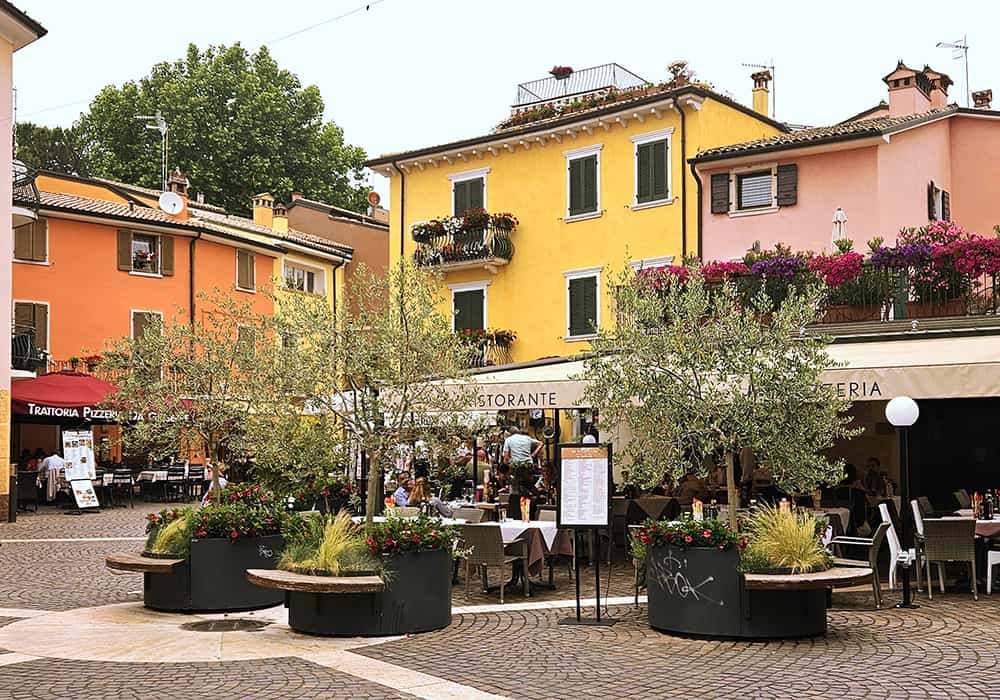 A historical village Centre with a street cafe and colourful houses in Bardolino