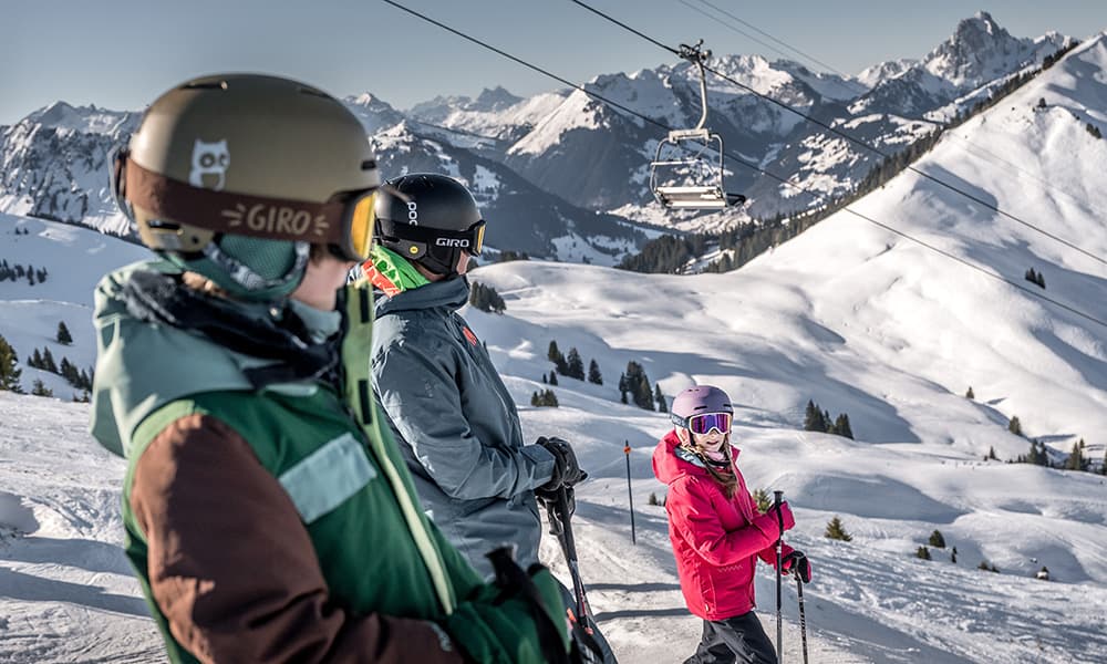 father and two children in their skigear in the Gstaad Saanenland ski domain in Switzerland