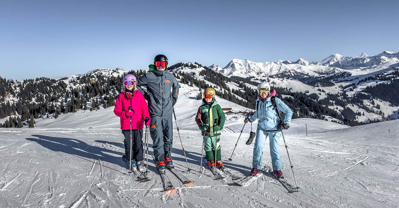 family skiing in Gstaad Saanenland on a suny day in Switzerland