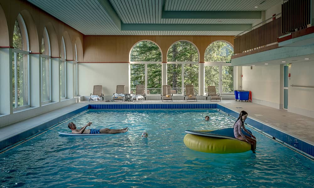 father and 2 kids in a swimming pool at a Swiss hotel in Arosa