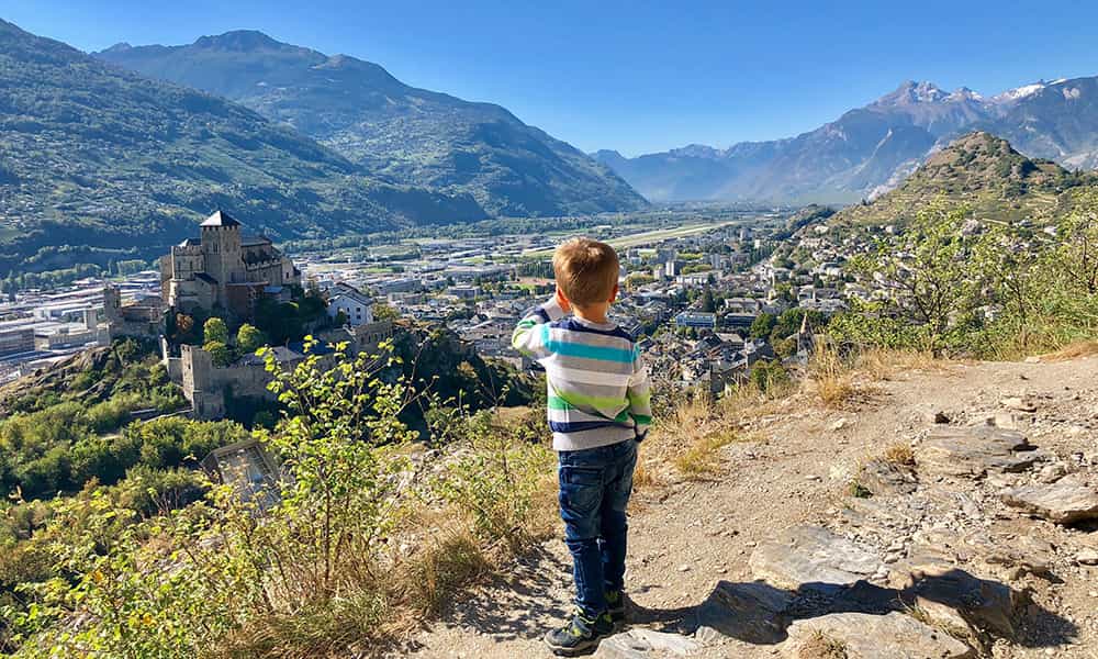 Boy looking towards Valère Castle above Sion in Valais Switzerland during spring