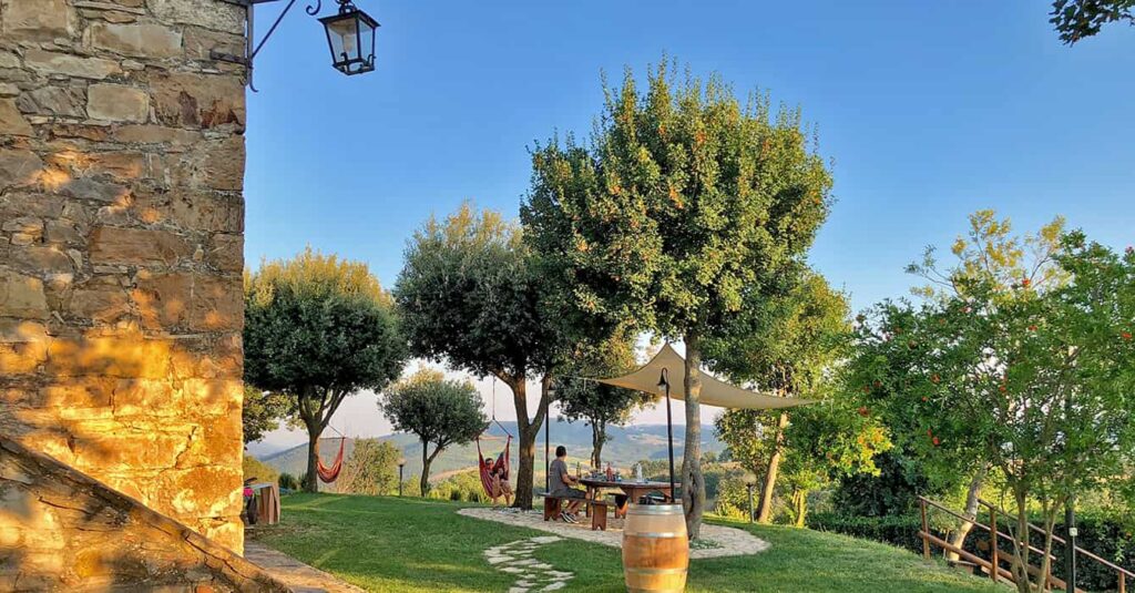 Family having lunch outside a traditional Tuscan farmhouse in Italy