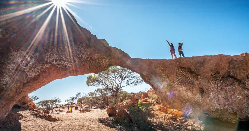 children standing atop a natural arch in western Australia,
