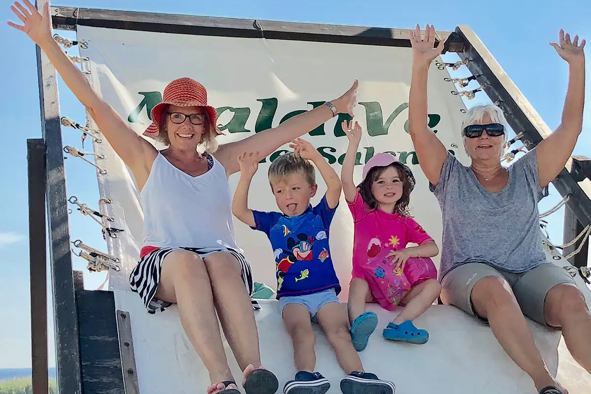 family sitting on an oversized beach chair in Italy