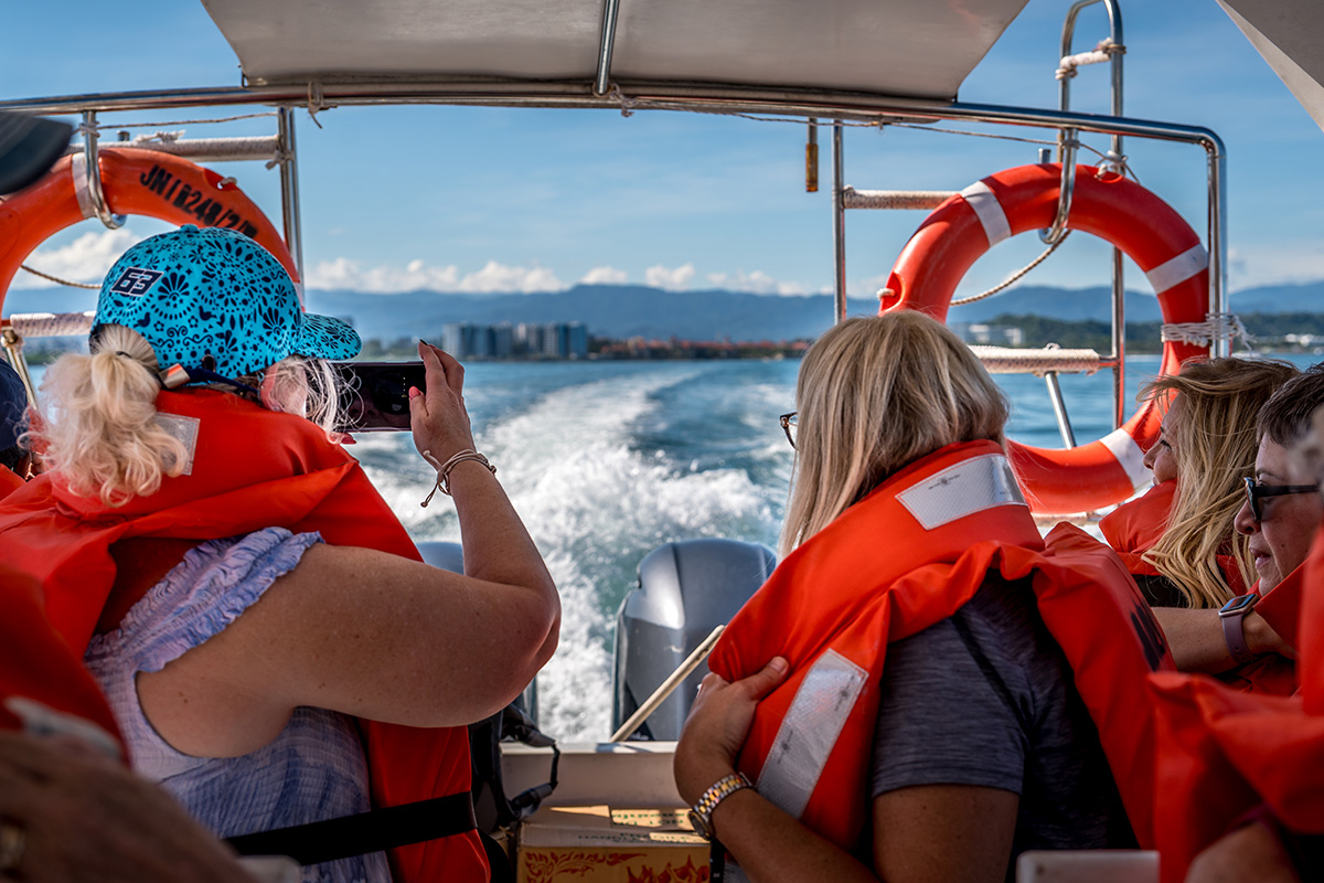 woman on a boat with their life-jacket and a phone