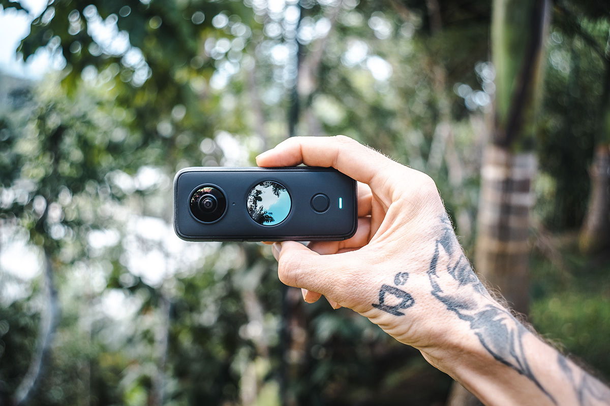 a man is holding a insta 360 travel camera