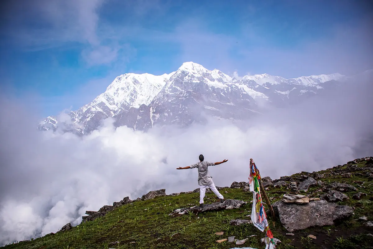 man holding his arms out infront of the himalayan mountains during the Everest base camp trek