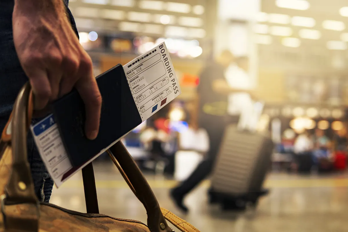 a man holding his flight tickets in his hand which he booked on a reputable site