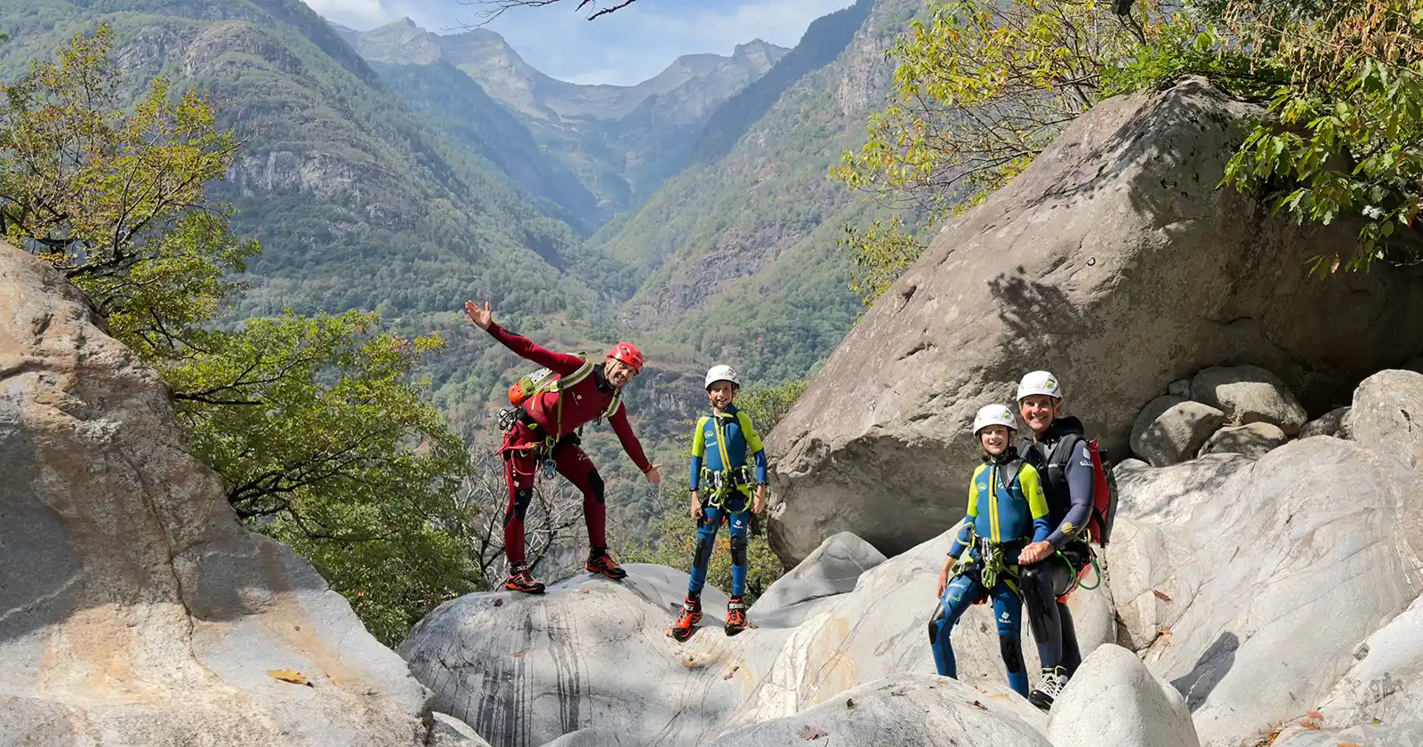 Family canyoning in the Boggera gorge in Ticino, family standing on the larg boulders